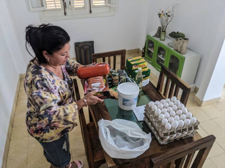 La Cubaine Maria Paez range la nourriture envoyée depuis Miami par ses enfants exilés, le 16 mai 2024 à La Havane  ( AFP / STRINGER )