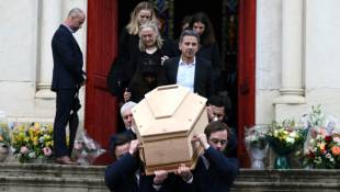 Le cercueil du journaliste littéraire Bernard Pivot est porté hors de l'église Saint-Pierre, après un service funéraire, le 14 mai 2024 à Quincié-en-Beaujolais, dans le Rhône ( AFP / JEAN-PHILIPPE KSIAZEK )