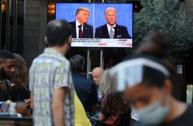 Diners en voorbijgangers kijken naar de uitzending van het eerste debat tussen voormalig president Donald Trump en de huidige president Joe Biden tijdens de 2020-campagne, in West Hollywood, Californië, 29 september 2020. (GETTY IMAGES NOORD-AMERIKA / MARIO TAMA)