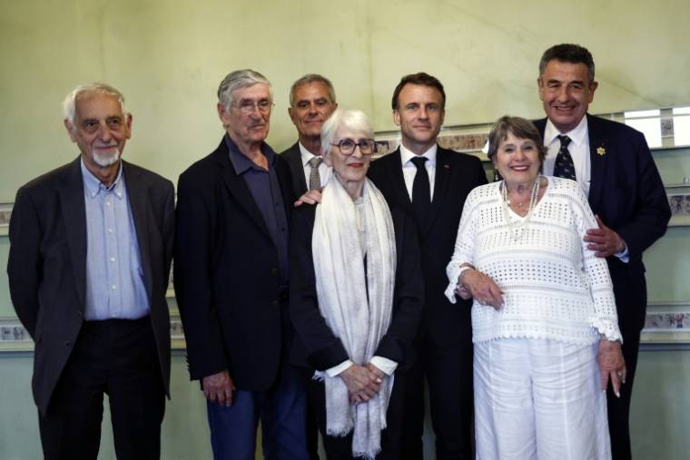 Le président Emmanuel Macron (C) pose avec d'anciens enfants de la maison d'Izieu, le 7 avril 2024 ( POOL / MOHAMMED BADRA )