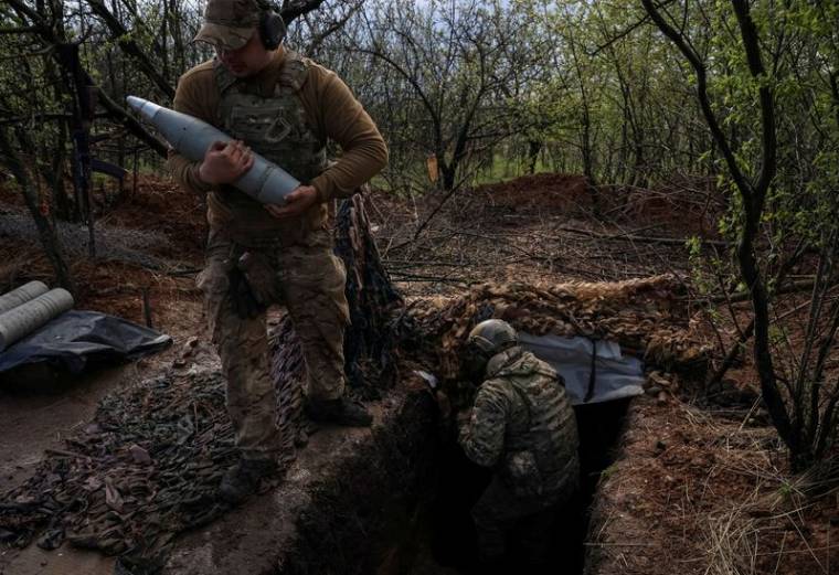 Des militaires ukrainiens préparent le tir d'un obusier D30 sur une ligne de front près de la ville de Bakhmout