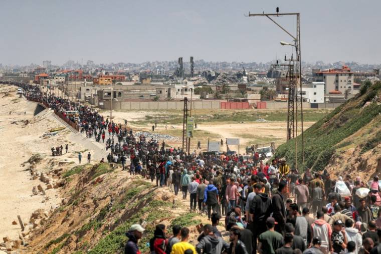 Des centaines de déplacés palestiniens marchent le long de la côte pour rejoindre le nord de la bande de Gaza, le 14 avril 2024 ( AFP / - )