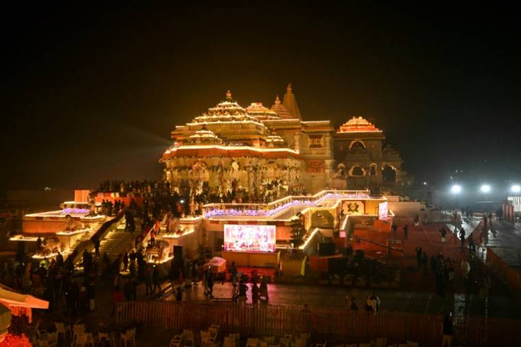 Des fidèles hindous se rassemblent près du temple dédié à la divinité Rama, illuminé après sa cérémonie de consécration, à Ayodhya, dans l'Etat indien de l'Uttar Pradesh, le 22 janvier 2024 ( AFP / Money SHARMA )