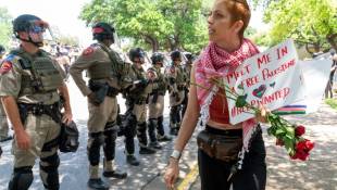 Une manifestante pro-palestinienne passe devant des soldats à l'Université du Texas à Austin (Etats-Unis), le 29 avril 2024 ( AFP / SUZANNE CORDEIRO )
