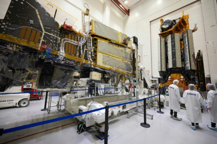 Des employés d'Airbus devant un satellite MetOp dans la "salle blanche" où l'on assemble les satellites à Toulouse, dans le sud-ouest de la France, le 10 novembre 2023 ( AFP / Lionel BONAVENTURE )