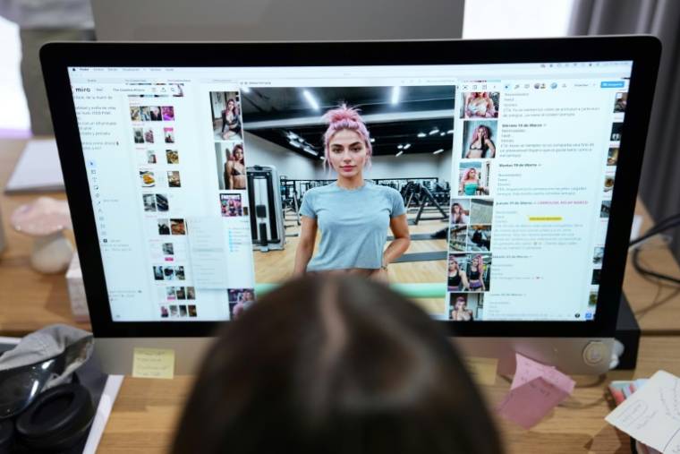 Diana Nunez, Spanish co-founder and artistic director of The Clueless agency, works on images generated by artificial intelligence of model Aitana Lopez, March 25, 2024 in Barcelona (AFP / PAU BARRENA)