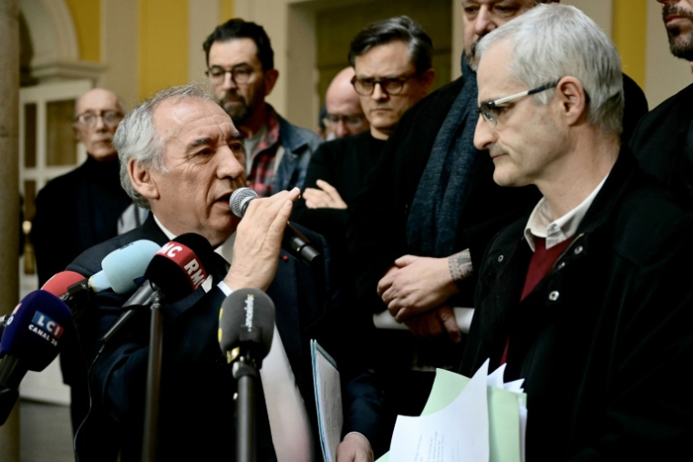 Le Premier ministre français François Bayrou (G) s'adresse à la presse après une rencontre avec des membres du collectif des victimes de violences de Notre-Dame-de-Betharram et son porte-parole Alain Esquerre (D) à la mairie de Pau, dans le sud-ouest de la France, le 15 février 2025 ( AFP / Philippe Lopez )