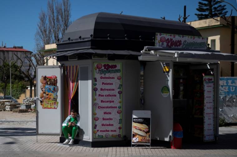 Un homme regarde son smartphone deant un kiosque à La Linea de la Concepcion, le 10 avril 2024 dans le sud de l'Espagne ( AFP / JORGE GUERRERO )