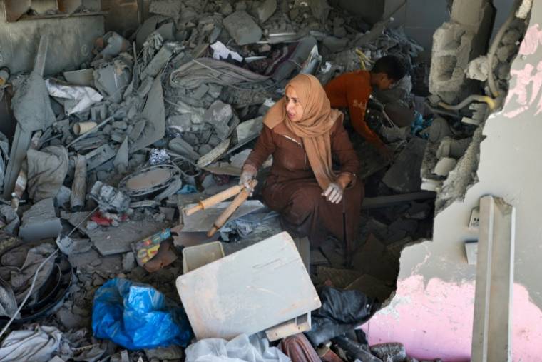 Une Palestinienne sauve quelques affaires d'une maison touchée par des bombardements israéliens nocturnes à Rafah, dans le sud de la bande de Gaza, le 20 avril 2024 ( AFP / - )