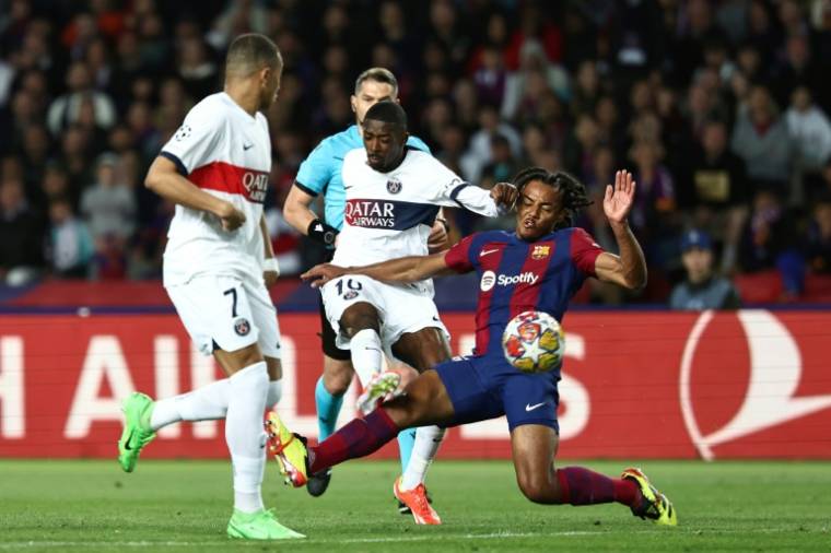 L'attaquant du PSG Ousmane Dembele aux prises avec son partenaire de l'équipe de France Jules Koundé, sous le maillot du Barça mardi en quart de finale retour de Ligue des champions à Barcelone. ( AFP / FRANCK FIFE )
