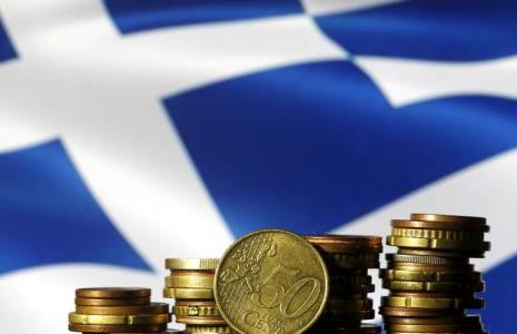 Les pièces en euros sont visibles devant un drapeau grec affiché dans cette illustration.