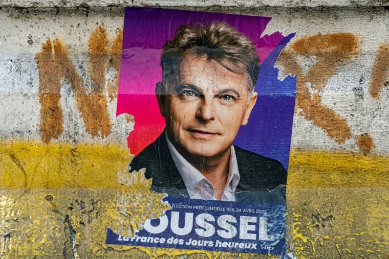 Une affiche de campagne de Fabien Roussel à Paris, le 18 mars 2022. ( AFP / JOEL SAGET )