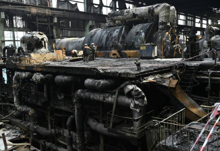 Des ouvriers nettoient les débris d'équipements calcinés dans une centrale électrique du fournisseur d'énergie DTEK, détruite après une attaque de missiles russes, le 19 avril 2024 en Ukraine  ( AFP / Genya SAVILOV )