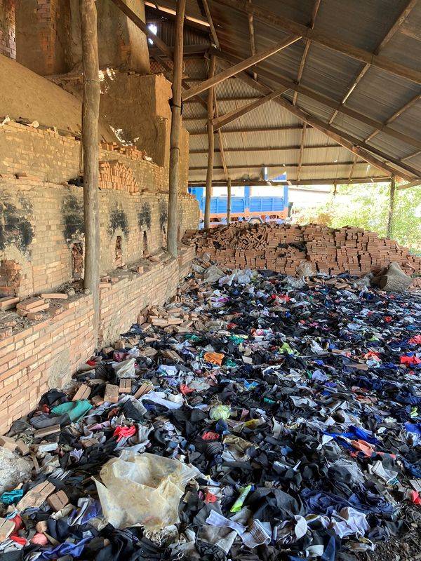 Déchets de marques internationales de vêtements stockés avant d'être utilisés pour alimenter les fours d'une usine de briques dans la banlieue de Phnom Penh