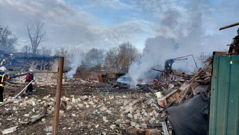 Des sauveteurs travaillent sur un site de maisons privées endommagées par un tir de missile russe à Kyiv