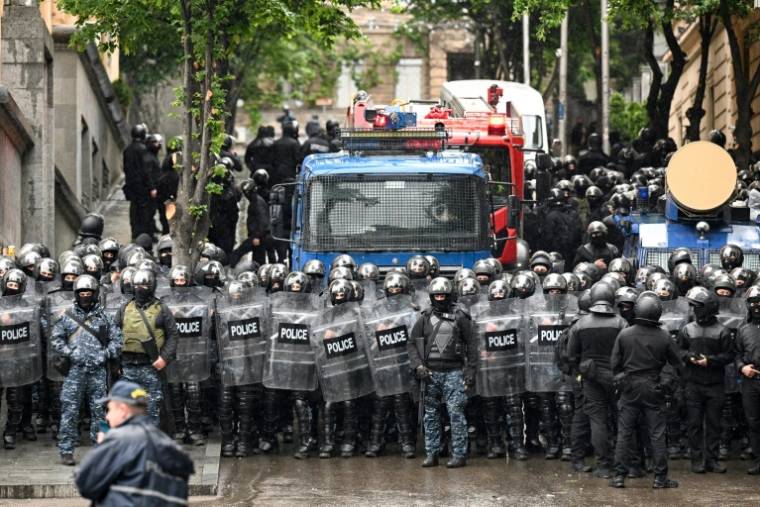 Des policiers déployés dans les rues de Tbilissi pendant une manifestation contre l'adoption par le Parlement d'un projet de loi controversé sur l'"influence étrangère", le 14 mai 2024 en Géorgie ( AFP / Vano SHLAMOV )