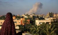 Une Palestinienne regarde de la fumée s'élever après une frappe isaélienne au sud de la ville de Gaza le 11 juin 2024 ( AFP / Eyad BABA )
