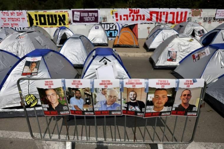 Des portraits d'otages sont accrochés près de tentes dans un camp monté par des manifestants anti-gouvernementaux israéliens à Jérusalem le 2 avril 2024  ( AFP / AHMAD GHARABLI )