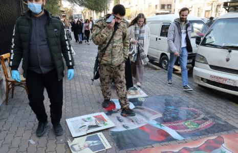 Des personnes marchent sur des portraits du président syrien déchu Bachar al-Assad à Damas, le 25 décembre 2024 ( AFP / ANWAR AMRO )