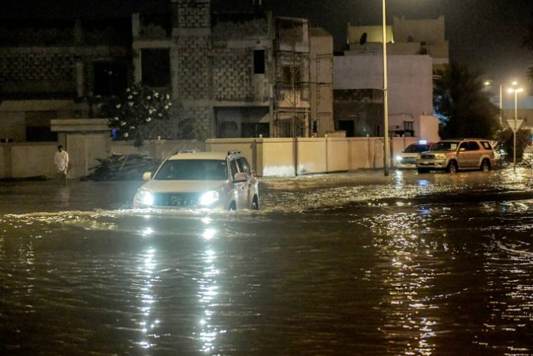 Un véhicule roule sur une route inondée dans la ville d'Isa, dans le sud de Bahreïn, le 16 avril 2024 ( AFP / Mazen Mahdi )
