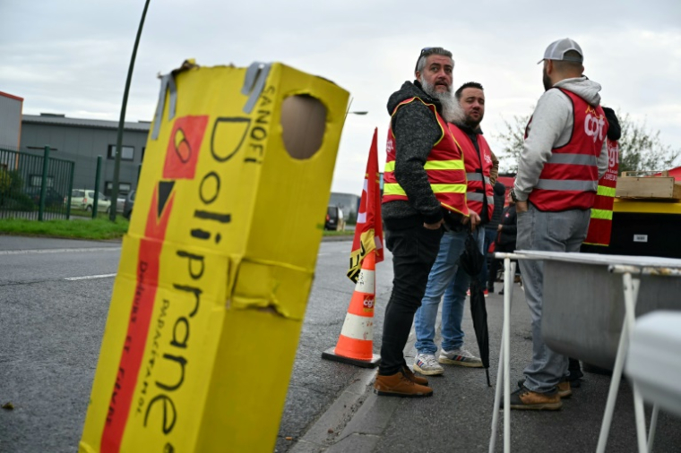 Des employés et des syndicalistes en grève devant leur usine qui fabrique le Doliprane à Lisieux (nord-ouest de la France), après l'annonce par Sanofi de négociation en cours avec le fonds d'investissement américain CD&R afin de lui céder potentiellement 50% de la  d'Opella, sa filiale qui commercialise notamment ce paracétamol en France. Photo prise le 17 octobre ( AFP / LOU BENOIST )