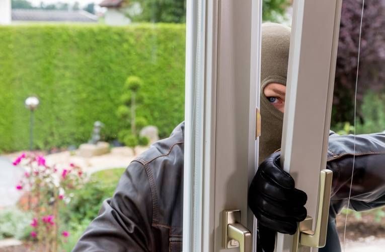 (Crédits photo : Adobe Stock - Homme cagoulé tentant une intrusion dans une maison par une porte-fenêtre)