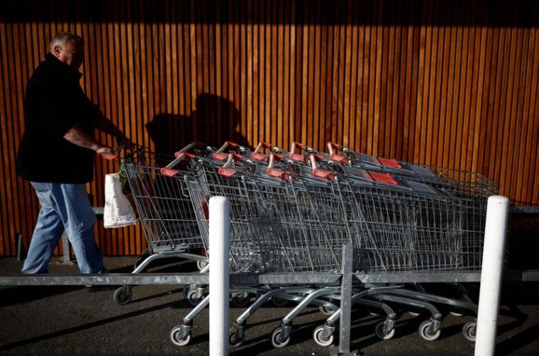 Un homme avec un chariot dans un supermarché à La Verrie