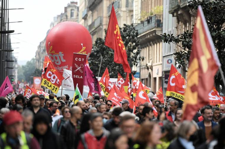 Des manifestants défilent avec des pancartes de la CGT lors du 1er mai 2022 à Toulouse. ( AFP / VALENTINE CHAPUIS )