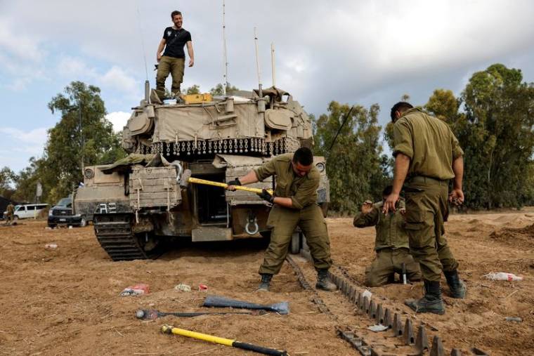 Des soldats israéliens réparent un char près de la frontière entre Israël et la bande de Gaza