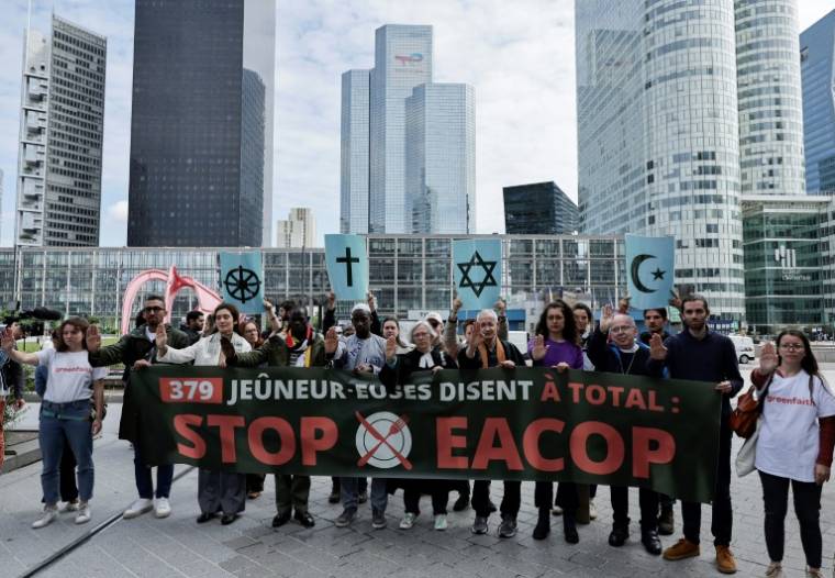 Manifestation de militants écologistes  devant le siège de TotalEnergies pendant l'assemblée générale du groupe, à Courbevoie, dans les Hauts-de-Seine, le 24 mai 2024 ( AFP / STEPHANE DE SAKUTIN )