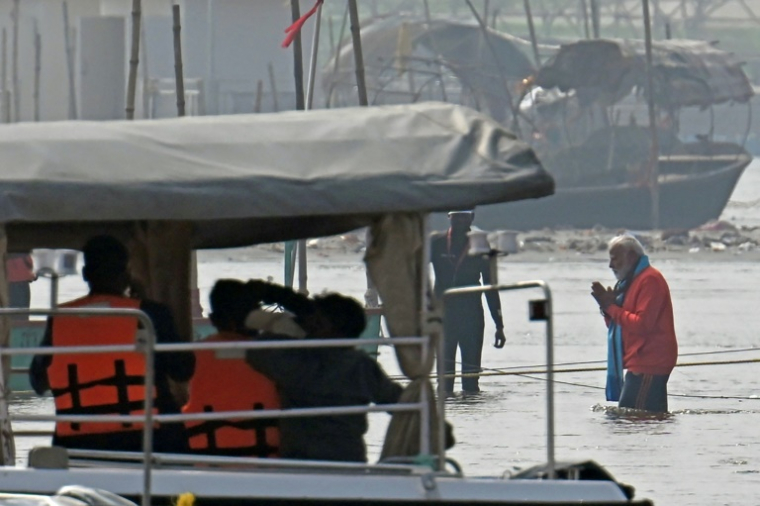 Le Premier ministre indien Narendra Modi (d) lors d'un bain rituel dans les eaux des fleuves sacrés du Gange, de la Yamuna et de la mythique Saraswati, lors du pèlerinage de la Kumbh Mela à Prayagraj, le 5 février 2025 ( AFP / Idrees MOHAMMED )