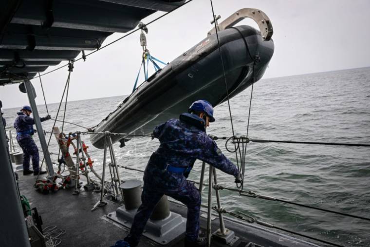Des soldats de la Marine roumaine remontent un canot de sauvetage à bord d'un chasseur de mines, lors d'un exercice en mer Noire, le 16 avril 2024 au large du port roumain de Constanta  ( AFP / Daniel MIHAILESCU )