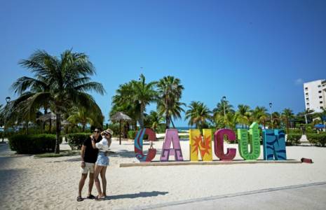 Un couple se prend en photo sur la plage à Cancun au Mexique le 23 avril 2024.  ( AFP / CARL DE SOUZA )