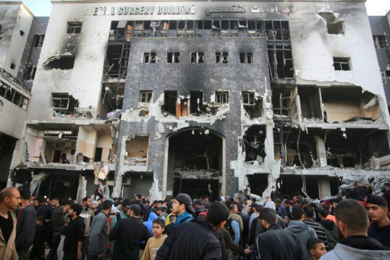 Des Palestiniens devant un  bâtiment détruit du complexe hopitalier après une opération de l'armée israélienne, le 1er avril 2024 ( AFP / - )