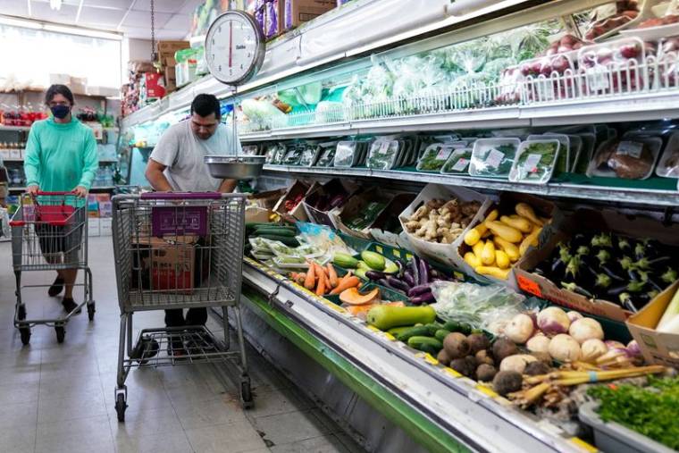 Un homme range des produits au supermarché Best World dans le quartier Mount Pleasant de Washington