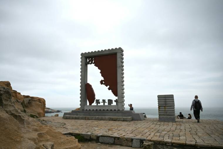 Un homme passe devant une sculpture représentant la carte de Taïwan sur un site touristique appelé "68 milles marins" situé sur l'île de Pingtan, dans la province chinoise du Fujian, dans le sud-est du pays, à l'endroit de Chine continentale le plus proche de l'île principale de Taïwan, le 24 mai 2024. ( AFP / Greg Baker )