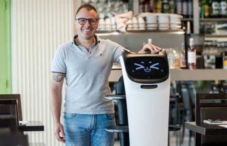 Geoffrey Ruamps, directeur du restaurant le Cap 180, pose avec le robot serveur "Bella" dans son restaurant, à Cieurac, dans le Lot, le 14 mai 2024 ( AFP / Matthieu RONDEL )