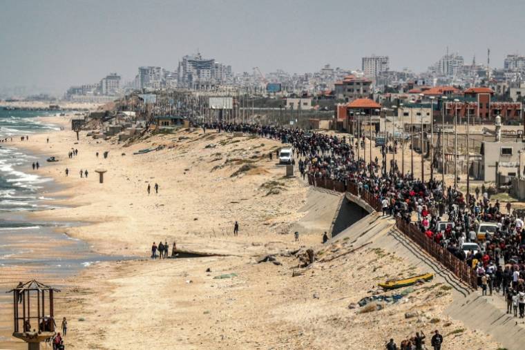 Des milliers de Palestiniens déplacés dans le sud de la bande de Gaza marchent, le 14 avril 2024, le long de la mer pour tenter de regagner le nord du territoire ( AFP / - )