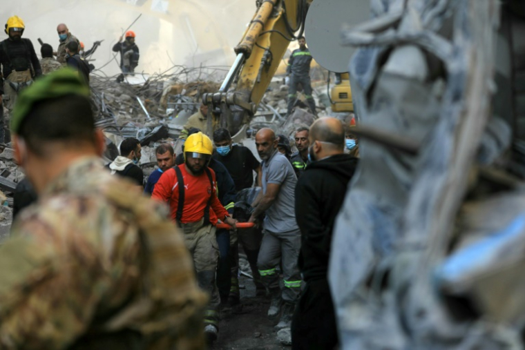 Des secouristes transportent le corps d'une victime extrait des décombres d'un immeuble détruit par une frappe aérienne israélienne dans le quartier de Basta dan s le centre de Beyrouth, le 23 novembre 2024 ( AFP / - )