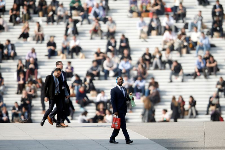 Des hommes d'affaires profitent du beau temps à l'heure du déjeuner sous l'Arche de la Défense