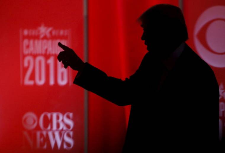Republican U.S. presidential candidate businessman Donald Trump speaks to someone offstage during a commercial break at the Republican U.S. presidential candidates debate sponsored by CBS News and the Republican National Committee in Greenville