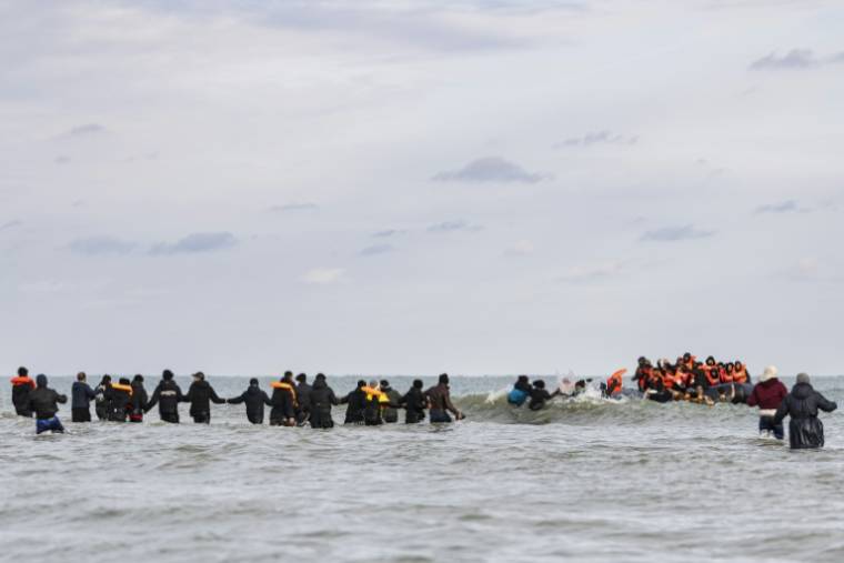 Des migrants montent à bord d'un bateau de passeurs pour traverser la Manche, sur la plage de Gravelines, près de Dunkerque, le 26 avril 2024 dans le Nord ( AFP / Sameer Al-DOUMY )