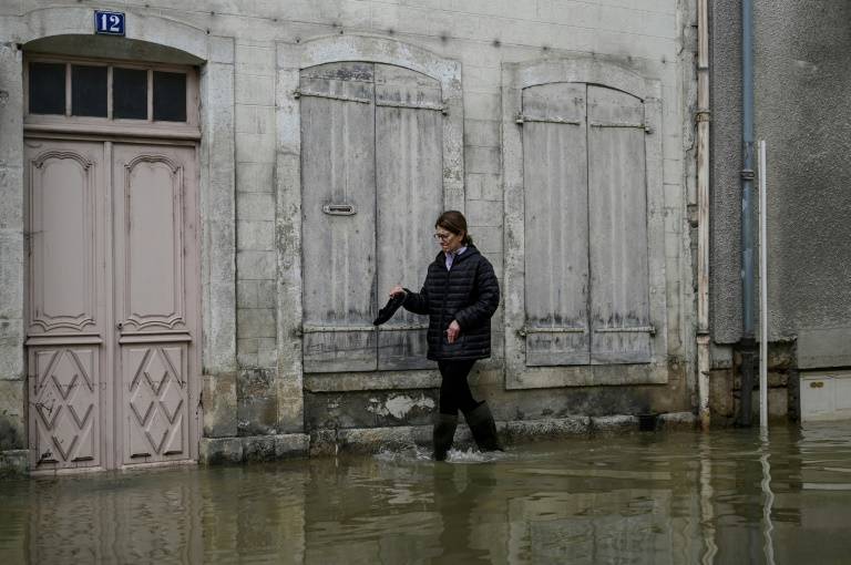 Une habitante dans une rue inondée de Montbard, le 2 avril 2024 en Côte-d'Or ( AFP / ARNAUD FINISTRE )