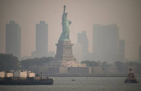 La Statue de la Liberté vue depuis un ferry le 6 juin 2023 alors que New York est enveloppé d'un brouillard de fumées dû à des feux de forêt au Québec ( AFP / Ed JONES )