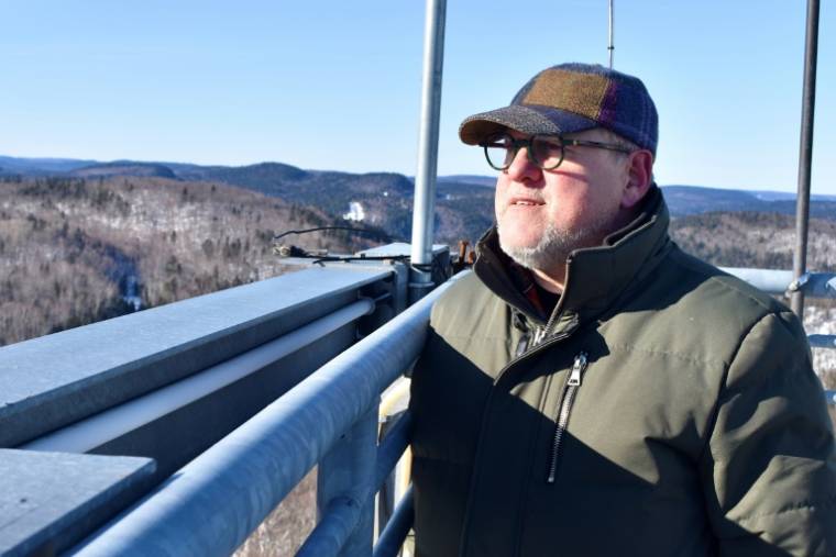 Yvan Lafontaine contemple son vaste terrain, visé par un claim minier, du haut d'une tour d'observation à St-Mathieu-du-Parc, Québec, Canada le 20 février 2024 ( AFP / Genevieve Normand )