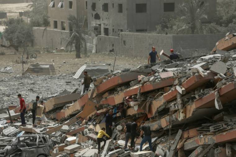 Des Palestiniens inspectent les décombres d'un bâtiment après des frappes israéliennes à Nousseirat, dans le centre de la bande de Gaza, le 18 avril 2024 ( AFP / - )