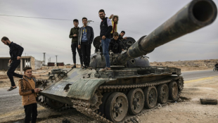 Des jeunes se tiennent sur un char dans les environs de Hama, dans le centre de la Syrie, le 11 décembre 2024 ( AFP / Sameer Al-DOUMY )