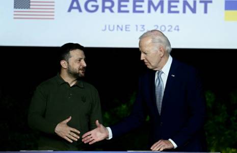 Le président ukrainien Volodymyr Zelensky (g) et son homologue américain Joe Biden se serrent la main après avoir signé un accord de sécurité bilatéral lors d'une conférence de presse en marge du G7, le 13 juin 2024 à Savelletri, en Italie ( AFP / Filippo MONTEFORTE )