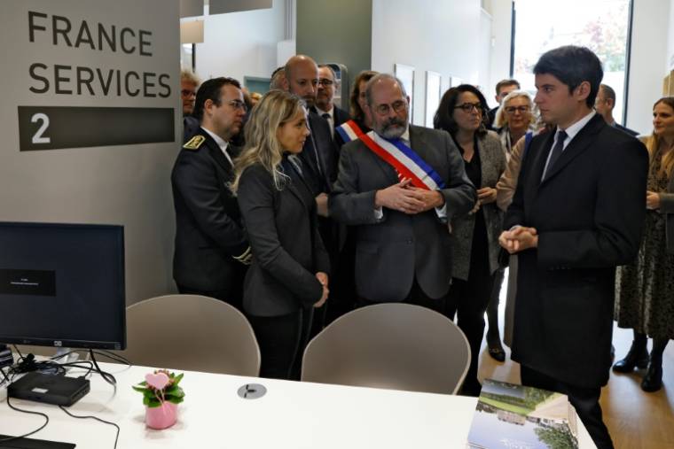 Le Premier ministre français Gabriel Attal (d) et le maire de Sceaux Philippe Laurent (c) lors de sa visite dans les locaux de " France Services" à Sceaux, le 23 avril 2024 dans les Hauts-de-Seine ( AFP / Ludovic MARIN )
