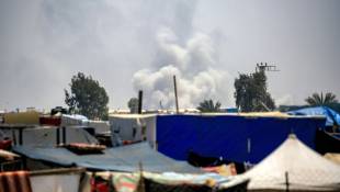 Un nuage de fumée s'élève dans le ciel près de tentes où habitent des déplacés à Rafah, le 4 juin 2024, à Rafah, dans le sud de la bande de Gaza, où une guerre oppose Israël au mouvement islamiste palestinien Hamas ( AFP / Eyad BABA )